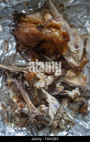 left over chicken and chicken bones on tin foil Stock Photo