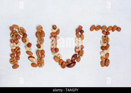 the word "nuts" from a mixture of nuts on a light background. view from above Stock Photo