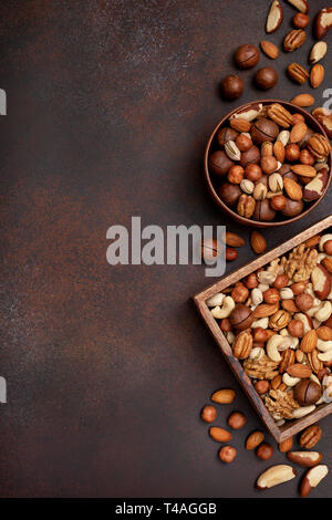 mix of nuts on a dark brown background. view from above. copy space Stock Photo