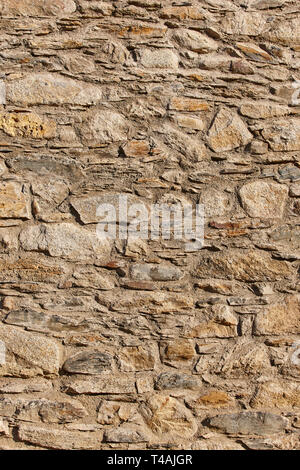 Natural stone wall facade detail. Textured rustic background. Vertical Stock Photo