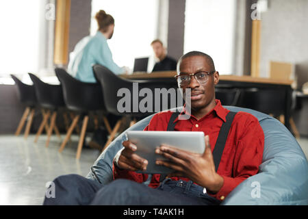 African -American Businessman Lounging in Office Stock Photo