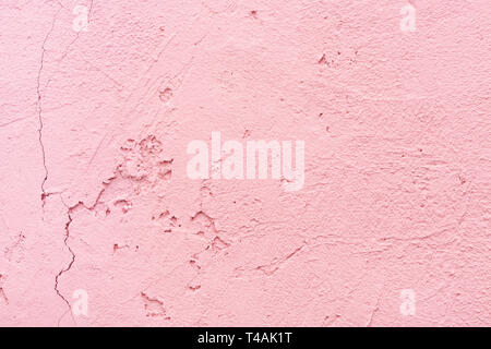 Cracked texture of plaster wall. Pink stucco close-up. Abstract background, interior decor. Stock Photo