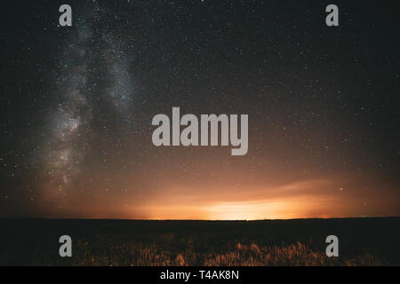 Natural Night Sky Stars With Milky Way Galaxy Above Field Landscape. Real Photo Starry Sky After Sunset Time. Stock Photo