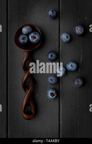 blueberries and wooden spoon on dark grey wooden background Stock Photo
