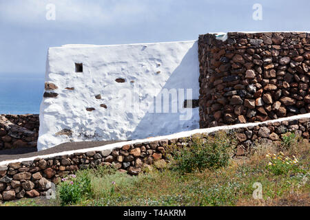 Volcanic stones and white concrete building walls on Lanzarote in Spain Stock Photo