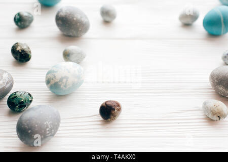 Stylish Easter eggs on white wooden background with space for text. Modern easter eggs painted with natural dye in blue and grey marble. Happy Easter, Stock Photo