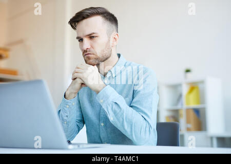 Pensive Man Using Laptop Stock Photo