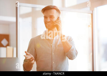 Contemporary Businessman Speaking by Phone in Sunlight Stock Photo