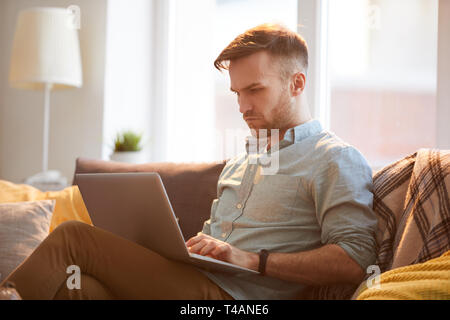 Handsome Man Using Laptop at Home Stock Photo