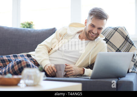 Young Man Lying on Sofa Stock Photo
