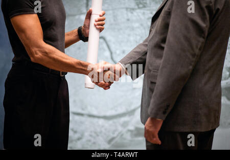 Architect handing blueprints to businessman. Stock Photo