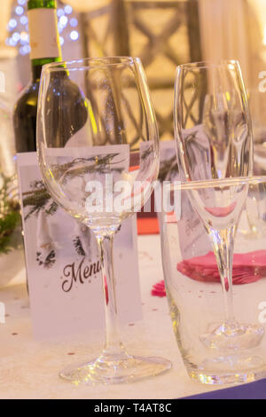 Reception and party table, with wine glass, and champagne glass, menu and bottle of wine Stock Photo