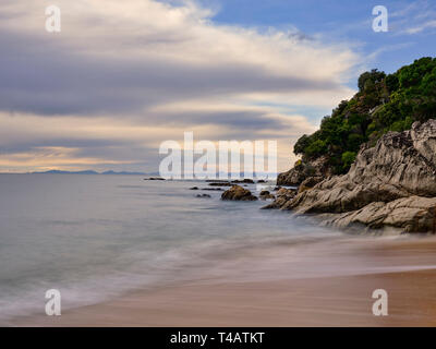 New Zealand, Nelson & Marlborough, Abel Tasman National Park. Dawn at the golden sand beach of Totaranui Bay which is bordered by native woodland and  Stock Photo