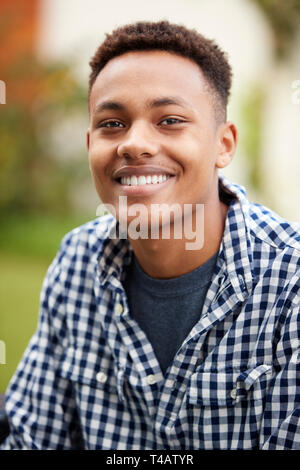 Young black man outdoors smiles to camera, close up, vertical Stock Photo