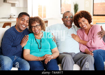Middle aged black couple and parents sitting at home, smiling to camera Stock Photo