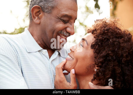 Senior man and his middle aged daughter smiling at each other embracing, close up Stock Photo