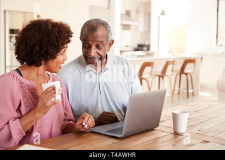 Senior black man and his middle aged daughter using a laptop together at home, close up Stock Photo