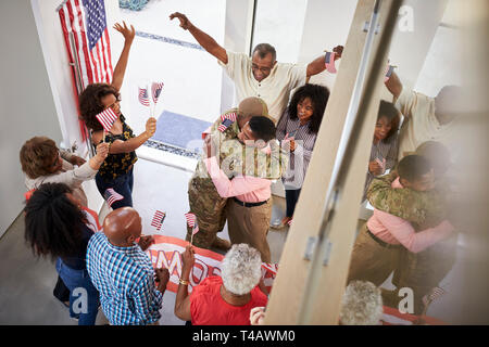 Young black male soldier welcomed home by three generation family, elevated view Stock Photo