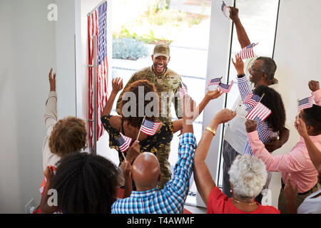 Young black male soldier returning home to his three generation family, elevated view, close up Stock Photo