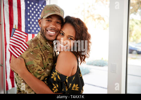 Millennial black soldier and his wife embracing at home and smiling to camera,close up Stock Photo