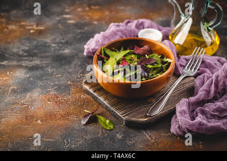 Fresh salad mix of baby spinach, arugula leaves and chard in wooden bowl, healthy food, Stock Photo