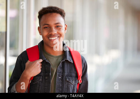 Portrait Of Smiling Male University Student With Backpack In Corridor Of College Building Stock Photo