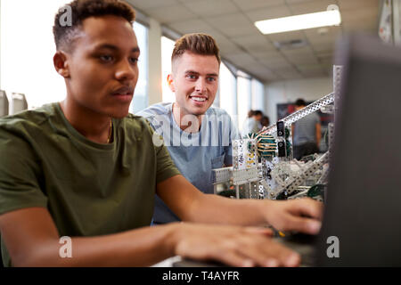 Two Male University Students Building Machine In Science Robotics Or Engineering Class Stock Photo