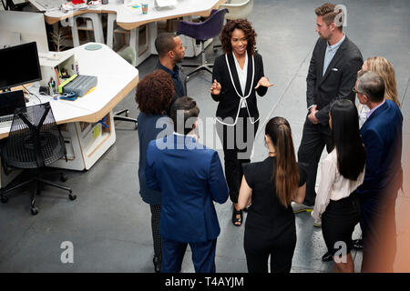 Business Team Standing Having Informal Meeting In Modern Office Stock Photo