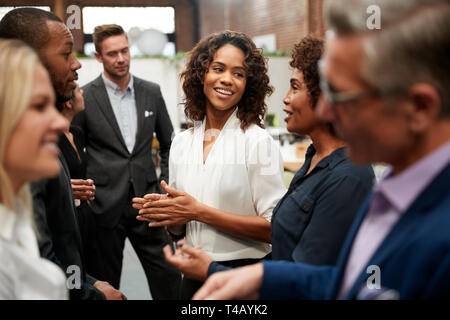 Business Team Standing Having Informal Meeting In Modern Office Stock Photo