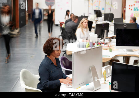 Business Team Working At Desks In Modern Open Plan Office Stock Photo