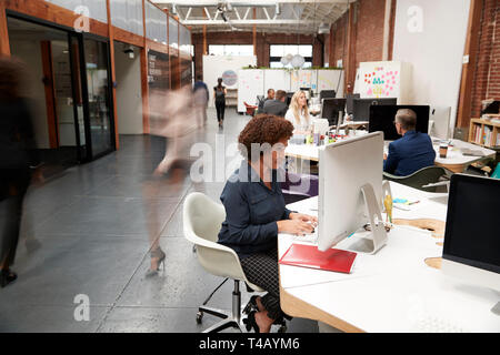 Business Team Working At Desks In Modern Open Plan Office Stock Photo