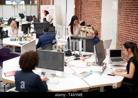 Business Team Working At Desks In Modern Open Plan Office Stock Photo