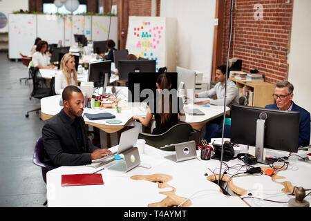 Business Team Working At Desks In Modern Open Plan Office Stock Photo