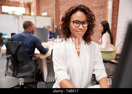 Female Customer Services Agent Working At Desk In Call Center Stock Photo