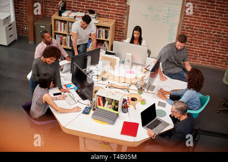 Casually Dressed Business Team Working At Desks In Modern Open Plan Office Stock Photo
