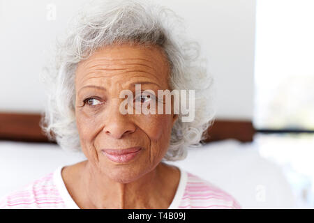 Depressed Woman Looking Unhappy Sitting On Side Of Bed At Home Stock Photo