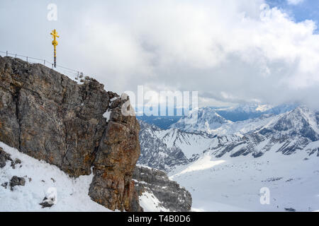 Summit cross on the Zugspitze, highest mountain of Germany in the snow covered Bavarian Alps near Garmisch Patenkirchen, copy space Stock Photo