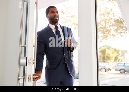 Businessman Wearing Suit Opening Door Returning Home From Work Stock Photo