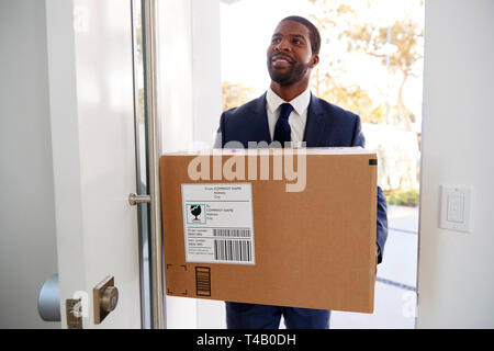 Businessman Carrying Box Opening Door Returning Home From Work Stock Photo