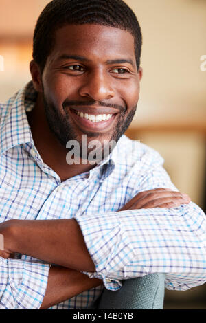 Smiling Man Relaxing On Sofa At Home Stock Photo