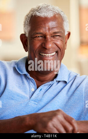 Smiling Senior Man Relaxing On Sofa At Home Stock Photo