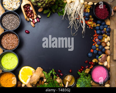 Super food or vegetarian food concept. Seeds, cereals, beans, vegetables, herbs for healthy cooking on black wooden background top view with copy spac Stock Photo