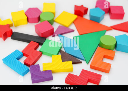 Multi-colored cubes and figures with numbers laid out randomly on a white background. Children learn to design from colored cubes. Wooden toys for chi Stock Photo