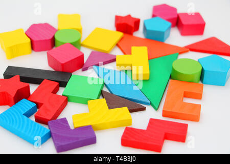 Multi-colored cubes and figures with numbers laid out randomly on a white background. Children learn to design from colored cubes. Wooden toys for chi Stock Photo