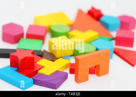 Multi-colored cubes and figures with numbers laid out randomly on a white background. Children learn to design from colored cubes. Wooden toys for chi Stock Photo