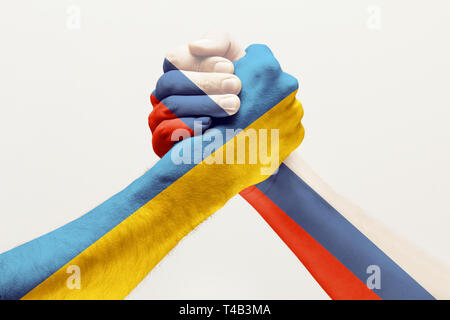 Stop to find out who's better. Two male hands fighting colored in Russia and Ukraine flags isolated on white studio background. Concept of political, economical, social aggressions, disagreement. Stock Photo