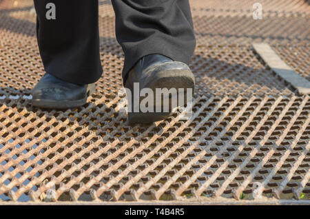 Man wearing old shoes doing hard step on a metal surface Stock Photo
