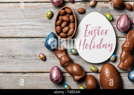 Chocolate easter eggs and bunnies on a rustic wooden background Stock Photo