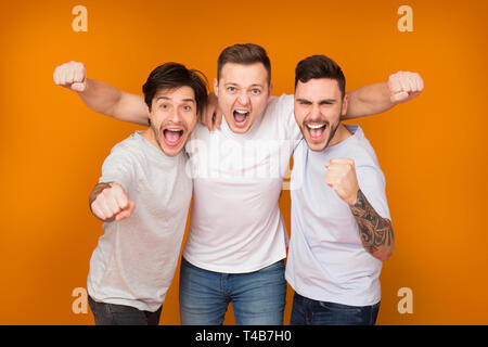 Yes. Cheerful men shouting and celebrating victory Stock Photo