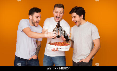 Celebrate meeting. Friends drinking beer and eating pizza Stock Photo